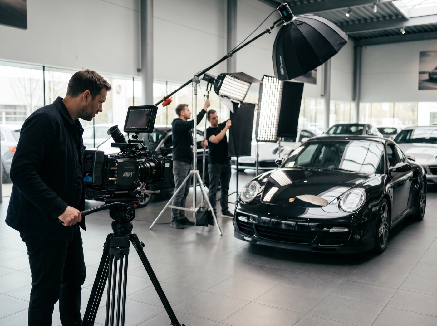 Equipa de fotografia profissional a fotografar um Porsche 911 no showroom